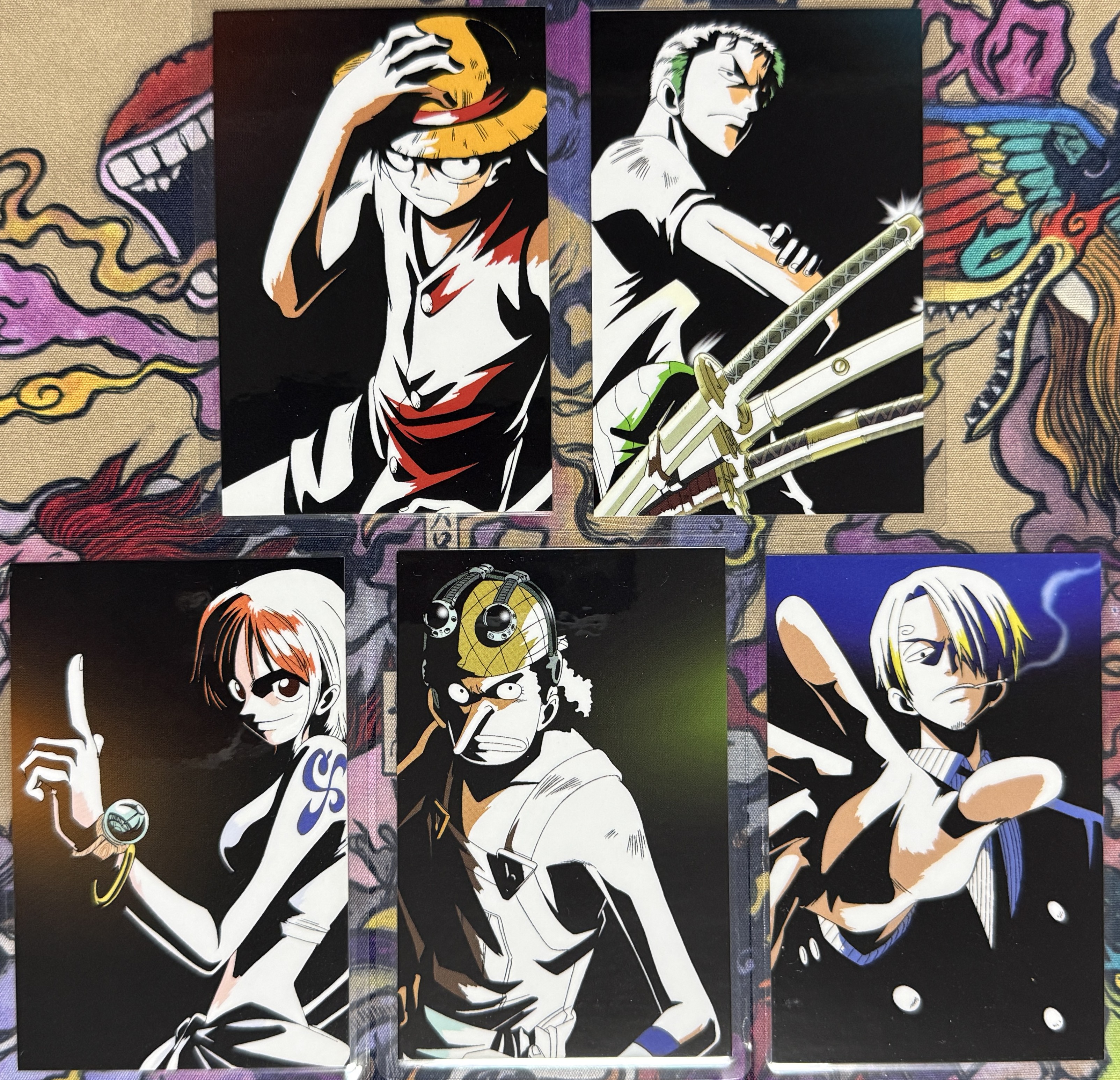 The five lami cards loose in a row, black-background artwork