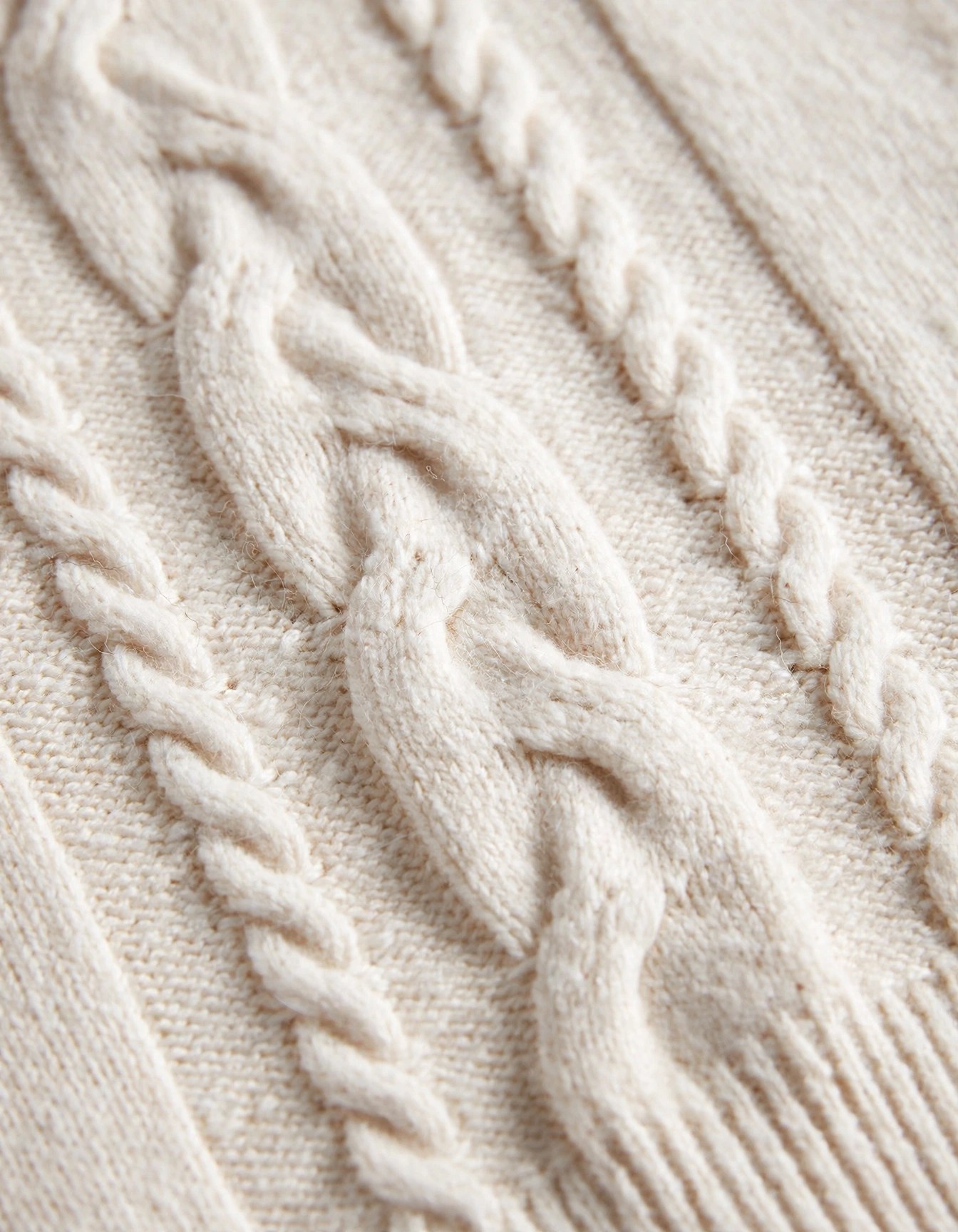 Close-up of the cream cable-knit texture
